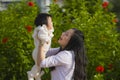 Young happy and cute Asian Chinese woman enjoying and playing with her baby girl daughter holding her raising up in her arms Royalty Free Stock Photo