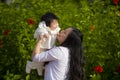 Young happy and cute Asian Chinese woman enjoying and playing with her baby girl daughter holding her raising up in her arms Royalty Free Stock Photo