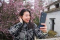 Young happy and cute Asian Korean tourist woman taking self portrait with mobile phone smiling cheerful Royalty Free Stock Photo