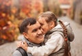 Young happy dad and little daughter hugging in autumn park. Family time, togehterness, parenting and happy childhood concept.