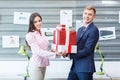 Young employees are standing with presents in the office. Royalty Free Stock Photo