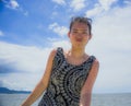 Young happy and excited Asian Chinese woman posing alone on a Summer sky looking cheerful and relaxed enjoying Royalty Free Stock Photo