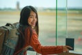 Young happy and excited Asian Japanese student woman with backpack at airport departure lounge watching aircraft through glass Royalty Free Stock Photo