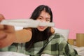 Young happy and excited Asian Korean woman in bed holding pregnancy test checking surprised positive pregnant result smiling ecsta Royalty Free Stock Photo