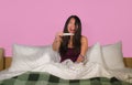 Young happy and excited Asian Korean woman in bed holding pregnancy test checking surprised positive pregnant result smiling ecsta Royalty Free Stock Photo