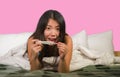 Young happy and excited Asian Korean woman in bed holding pregnancy test checking surprised positive pregnant result smiling ecsta Royalty Free Stock Photo