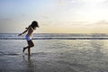 Young happy and excited Asian woman having fun enjoying playful and free at sunset beach in tourism vacation Royalty Free Stock Photo