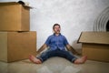 Young happy and excited man at home floor enjoying unpacking cardboard boxes moving alone to new apartment or house smiling Royalty Free Stock Photo