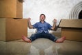 Young happy and excited man at home floor enjoying unpacking cardboard boxes moving alone to new apartment or house smiling Royalty Free Stock Photo