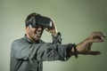 Young happy and excited man wearing virtual reality VR goggles headset experimenting 3d illusion playing video game touching Royalty Free Stock Photo