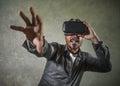 Young happy and excited man wearing virtual reality VR goggles headset experimenting 3d illusion playing video game touching Royalty Free Stock Photo