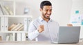 Young happy and excited mixed race businessman cheering in support while working on a laptop alone in an office at work Royalty Free Stock Photo