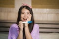 Young happy excited pregnant Asian Chinese woman at home holding predictor and checking positive result on pregnancy test feeling Royalty Free Stock Photo