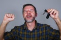 Young happy and excited 30s or 40s attractive man holding car key celebrating buying new automobile or motorbike isolated on grey Royalty Free Stock Photo