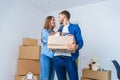 Young happy family with cardboard boxes opening door of their new home and coming in at empty flat. Royalty Free Stock Photo