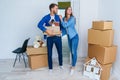 Young happy family with cardboard boxes opening door of their new home and coming in at empty flat. Royalty Free Stock Photo