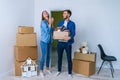 Young happy family with cardboard boxes opening door of their new home and coming in at empty flat. Royalty Free Stock Photo