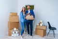 Young happy family with cardboard boxes opening door of their new home and coming in at empty flat. Royalty Free Stock Photo