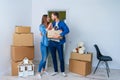 Young happy family with cardboard boxes opening door of their new home and coming in at empty flat. Royalty Free Stock Photo