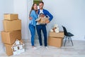 Young happy family with cardboard boxes opening door of their new home and coming in at empty flat. Royalty Free Stock Photo