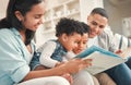 Young happy family, children reading and sofa for story, book and learning together in home, love and bonding. Parents Royalty Free Stock Photo