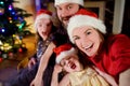 Young happy family of four taking a photo of themselves on Christmas Royalty Free Stock Photo