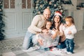 Miling young family in Christmas atmosphere making photo with smartphone Royalty Free Stock Photo