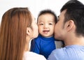 young happy family kissing baby