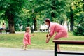 Young happy family with little beautiful baby with blue eyes walking in summer park at sunset. Mom and little daughter Royalty Free Stock Photo