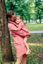 Young happy family with little beautiful baby with blue eyes walking in summer park at sunset. Mom and little daughter Royalty Free Stock Photo