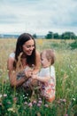 Young happy family with little beautiful baby with blue eyes walking in summer park at sunset. Royalty Free Stock Photo