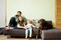 Young happy family with little toddler kid and dog labrador retriever at home on the couch, stay home concept Royalty Free Stock Photo