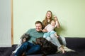 Young happy family with little toddler kid and pets dog and cat at home on the couch Royalty Free Stock Photo