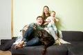 Young happy family with little toddler kid and pets dog and cat at home on the couch Royalty Free Stock Photo