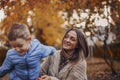 Young happy family loving mother and little boy son walking outdoors on autumn day Royalty Free Stock Photo