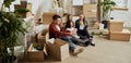 Young happy family, man, woman and kid sittin on floor in new living room. Moving into new flat, apartment with many Royalty Free Stock Photo