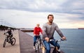 Young family riding bicycles outdoors on beach. Royalty Free Stock Photo