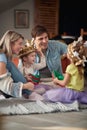 Young happy family sitting on the floor and playing at home together. Family, playing, home, togetherness