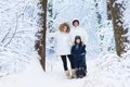 Young happy family with son walking in snowy park Royalty Free Stock Photo