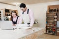 Young happy family standing at a work bench in a carpentry workshop, writing a project. Family business. startup business. young Royalty Free Stock Photo