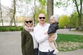 Young happy family in sunglasses of three having fun together outdoor. Pretty little daughter on her father back. Royalty Free Stock Photo