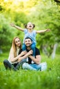 Young happy family of three having fun together outdoor. Pretty little daughter on her father piggyback smiling and have fun. Royalty Free Stock Photo