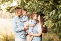 Young happy family with two children in nature in the summer walk. Healthy Smiling Dad, Mom and kids together Royalty Free Stock Photo