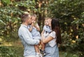 Young happy family with two children in nature in the summer walk. Healthy Smiling Dad, Mom and kids together Royalty Free Stock Photo