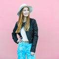 Young happy fashion blogger girl posing near the wall wearing casual street style outfit