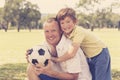 Young happy father and excited 7 or 8 years old son playing together soccer football on city park garden posing sweet and loving h Royalty Free Stock Photo