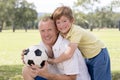 Young happy father and excited 7 or 8 years old son playing together soccer football on city park garden posing sweet and loving h Royalty Free Stock Photo