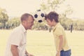 Young happy father and excited 7 or 8 years old son playing together soccer football on city park garden posing sweet and loving h Royalty Free Stock Photo