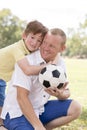 Young happy father and excited 7 or 8 years old son playing together soccer football on city park garden posing sweet and loving h Royalty Free Stock Photo