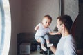 Young happy father holding baby son in hands over his head. Royalty Free Stock Photo